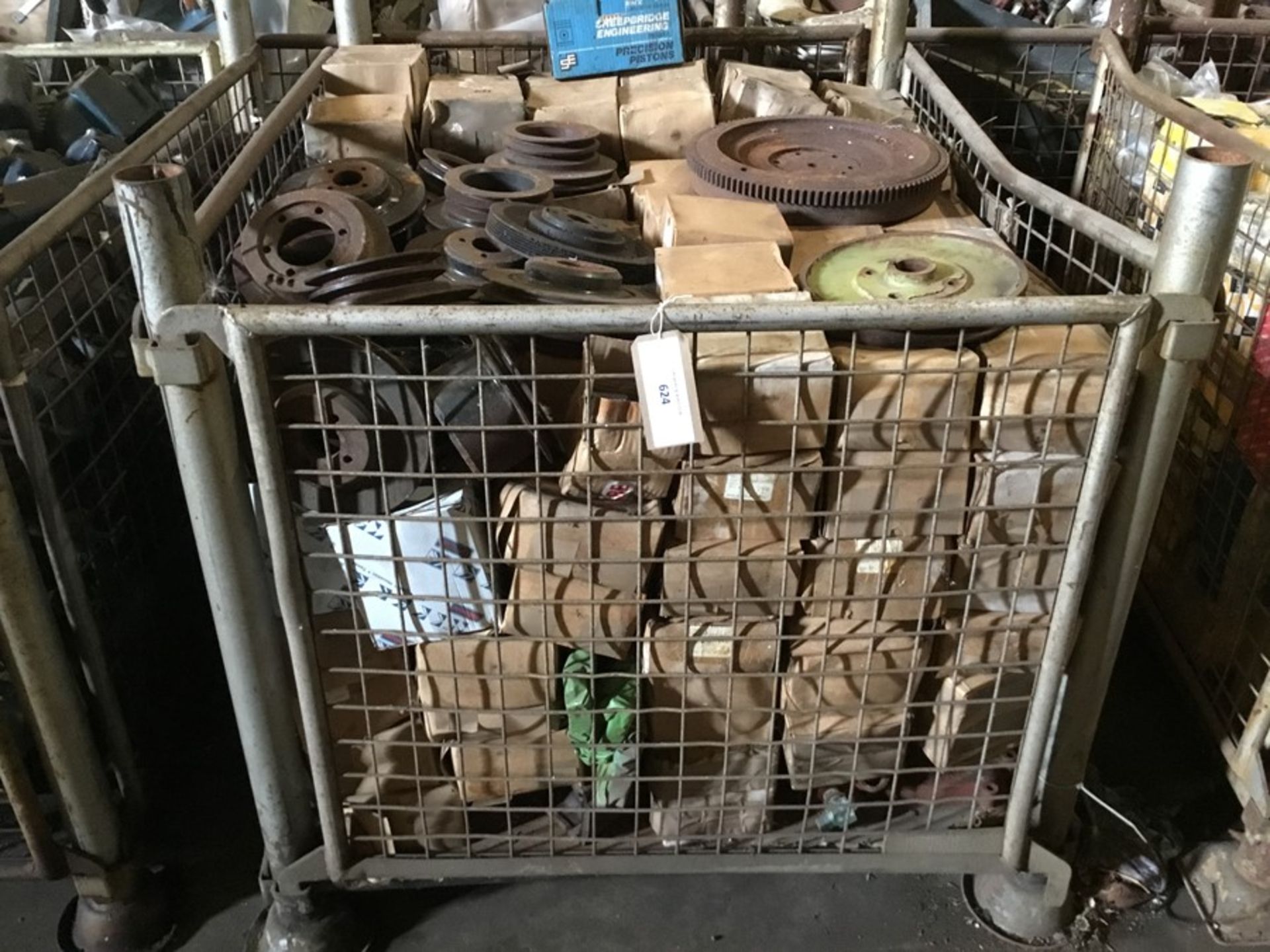 Cage containing misc. pullies, gaskets flywheel, Austin pistons etc