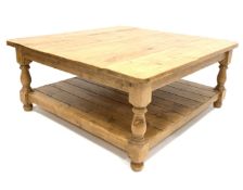 Large 20th century waxed pine square coffee table, raised on turned supports joined by under tier,