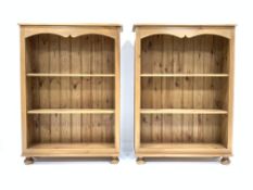 Pair 20th century polished pine open bookcase, each with two shelves raised on compressed bun feet,