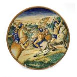 Italian maiolica plate of Urbino style decorated with soldiers on horseback on a low footed base