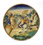 Italian maiolica plate of Urbino style decorated with soldiers on horseback on a low footed base