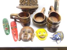 Five carved and painted Eastern face masks, carved wall bracket, didgeridoo,