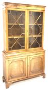 George III style mahogany bookcase on cupboard, moulded cornice above two astragal glazed doors,