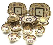 Cauldon tea service decorated with sprays of flowers within a blue and gilt leaf pattern border