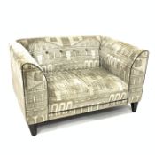 DFS snuggle chair, upholstered fabric with architectural pattern, ebonised tapering supports,