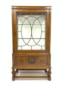 Early 20th century medium oak display cabinet, leaded glazed door enclosing two glass shelves,