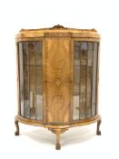 Early 20th century walnut demi-lune display cabinet, scroll carved raised back,