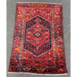 Persian Hamadan red ground rug, lozenge medallion on red field,
