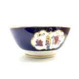 19th Century English porcelain punch bowl painted with panels of Chinese figures on a dark blue