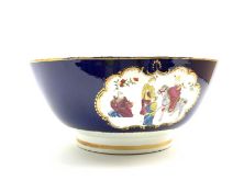 19th Century English porcelain punch bowl painted with panels of Chinese figures on a dark blue