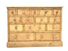 20th century pine chest, with moulded top above fourteen assorted drawers, turned handles,