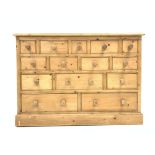 20th century pine chest, with moulded top above fourteen assorted drawers, turned handles,