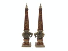 Pair of contemporary Chinese pottery obelisks with animals and foliage on a red ground and with