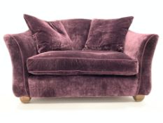 Christopher Pratt's snuggler sofa upholstered in purple velvet fabric, block supports,