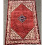 Persian ground rug, lozenge medallion on red field with boteh motif, ivory border,