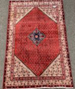 Persian ground rug, lozenge medallion on red field with boteh motif, ivory border,