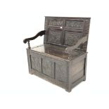 Oak settle, the raised back carved with panels of stylised flowers above a hinged box seat,