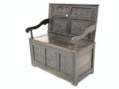 Oak settle, the raised back carved with panels of stylised flowers above a hinged box seat,