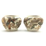 Pair of early 20th Century pottery Jardinieres decorated with a raised pattern of winged lions etc