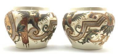 Pair of early 20th Century pottery Jardinieres decorated with a raised pattern of winged lions etc