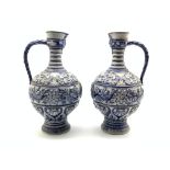 Pair of 19th Century Westerwald stoneware ewers decorated in relief with masks,