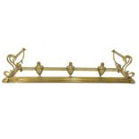 Edwardian brass fire curb with scroll ends,