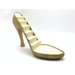 Shop display stand in the form of a gold high heeled shoe,