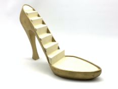 Shop display stand in the form of a gold high heeled shoe,