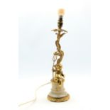 Gilt metal table lamp and shade of rococo design with a cherub holding a trident on a marble base