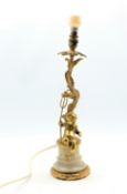 Gilt metal table lamp and shade of rococo design with a cherub holding a trident on a marble base