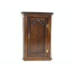 19th century oak wall hanging corner cupboard, dentil cornice over fielded panelled door,
