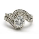 Two platinum rings, one set with a round brilliant cut diamond and diamond shoulders,