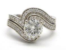 Two platinum rings, one set with a round brilliant cut diamond and diamond shoulders,