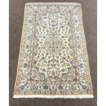 Persian ivory ground rug, decorated with scrolling foliage and central medallion,