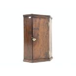 late 19th century oak wall hanging corner cupboard, with plain door enclosing two shelves,