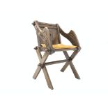 20th century oak Glastonbury chair, carved with roundel and Latin script, raised on cruciform base,