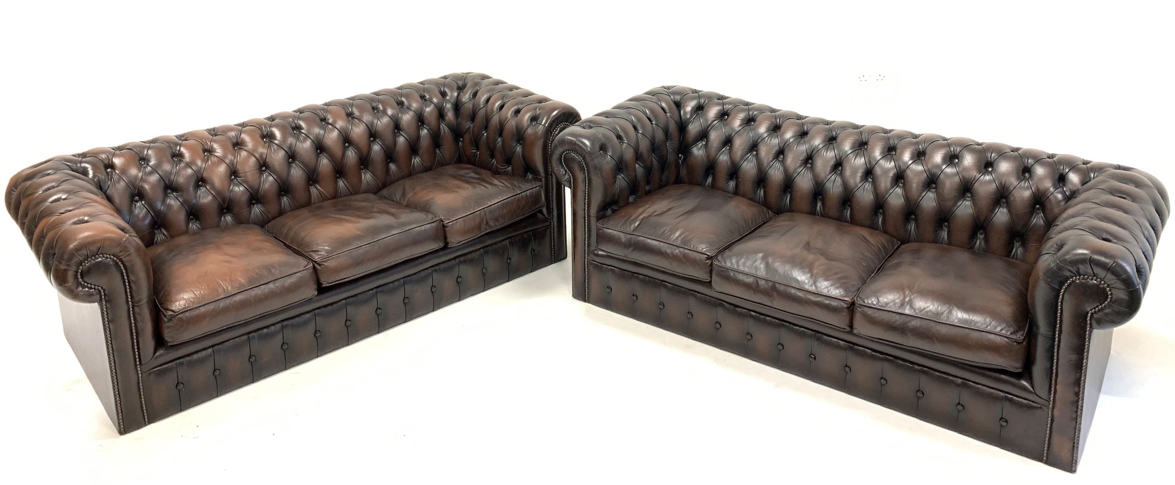 Pair of 20th century Chesterfield sofas, upholstered in deep buttoned brown leather,