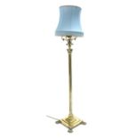 Early 20th century brass Corinthian column standard lamp, with shade, stepped base, and paw feet,