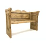 Late Victorian pine settle, with shaped top rail, turned pilasters and panel end supports,