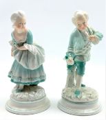 Pair of 19th Century porcelain male and female figures each holding a flower on blue lined circular