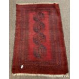 Afghan Bokhara red ground rug, with repeating gul motif on red field, and multi line border,