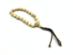 Ivory bracelet, formed of ivory beads carved as skulls separated by circular ivory beads,