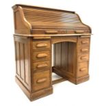 Early 20th century oak twin pedestal roll top desk, tambour front enclosing drawers and cubby holes,