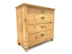 20th century varnished pine chest of four long graduating drawers, on turned bun feet,