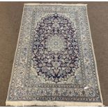 Persian design ivory ground rug, central medallion and trailing foliate on blue field,