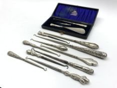 Ten various silver handled button hooks and a cased button hook and shoe horn with similar glove