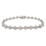 White gold flower design line bracelet, stamped 18K, total diamond weight 5.