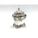 Edwardian silver tea caddy of bombe form with embossed decoration on scroll feet H15cm Sheffield