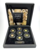 Seven miniature gold coins forming 'The Seven Wonders of the Coin World Gold Edition',