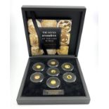 Seven miniature gold coins forming 'The Seven Wonders of the Coin World Gold Edition',